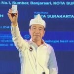 Joko Widodo menunjukkan Kartu Tanda Anggota PSI saat menghadiri Rakorda PSI di Bandung, Jawa Barat.